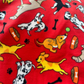 Fabric with cartoon dogs and bones on a red background